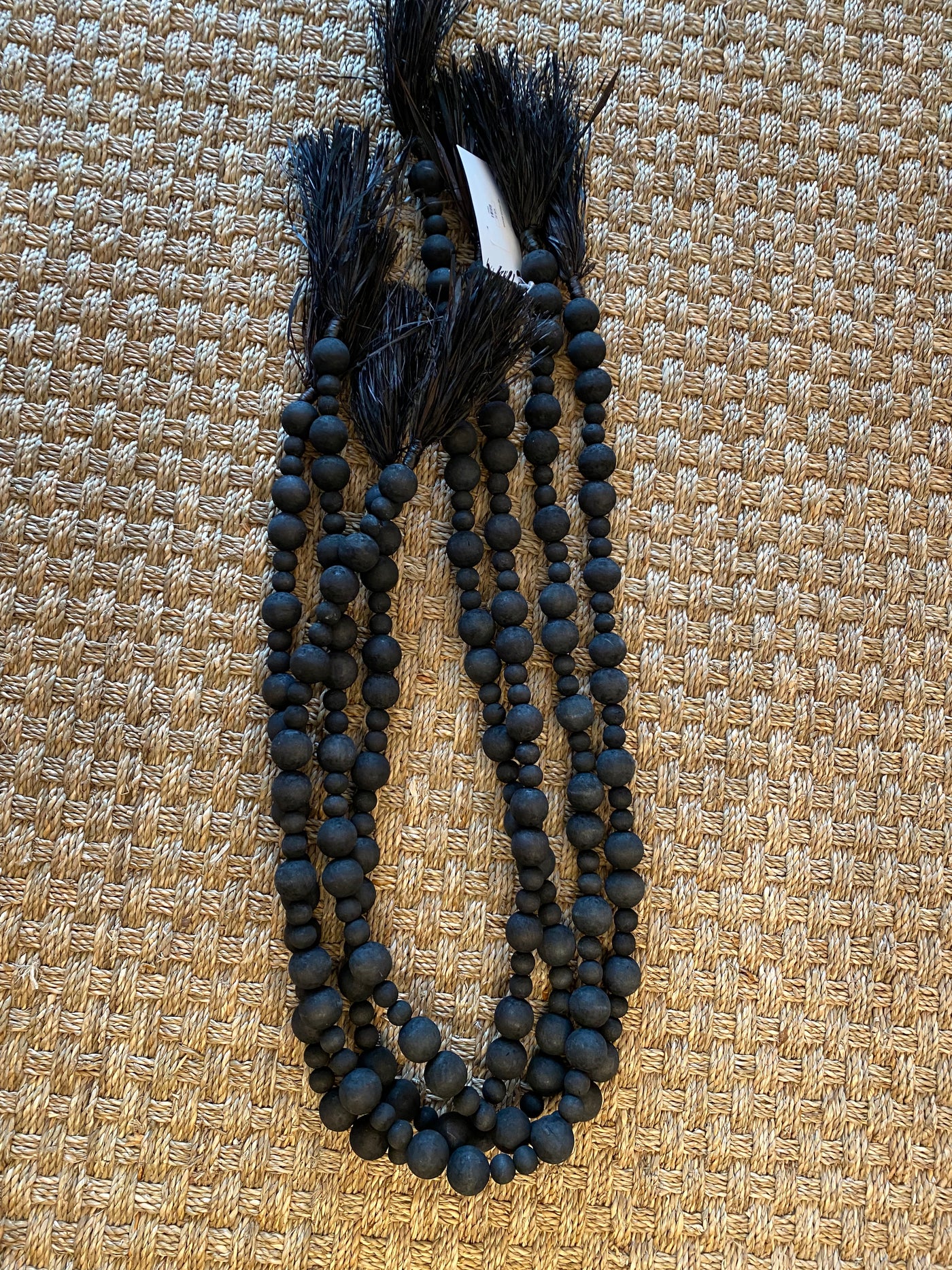 Black wooden bead strand with raffia fringe
